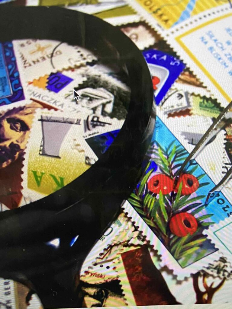 Magnifying glass over postage stamps.