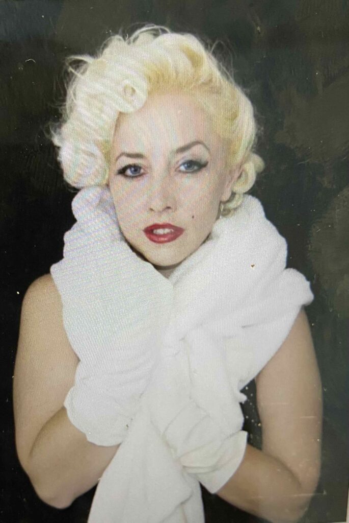 Woman with blonde ringlets hair and blue eyes.